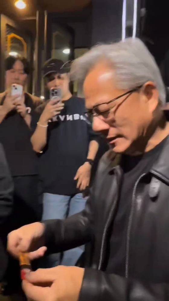Nvidia CEO Jensen Huang is seen receiving a JungKwanJang red ginseng extract stick outside a chicken restaurant in Gangnam District, southern Seoul on Oct. 30. [SCREEN CAPTURE]