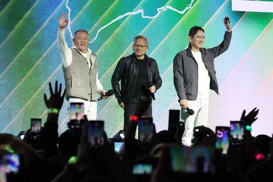 Nvidia CEO Jensen Huang, center, greets the audience alongside Samsung Electronics Executive Chairman Lee Jae-yong, right, and Hyundai Motor Group Executive Chair Euisun Chung during the GeForce Gamer Festival at Coex Square in Gangnam District, southern Seoul, on the night of Oct. 30, celebrating the 25th anniversary of GeForce in Korea. [JOINT PRESS CORPS]