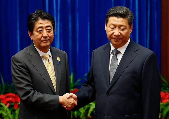 2014년 11월 10일 일본의 고(故) 아베 신조 전 일본 총리가 베이징 인민대회당에서 열린 회담 중 중국의 시진핑 국가주석(오른쪽)과 악수하고 있다. [게티이미지]