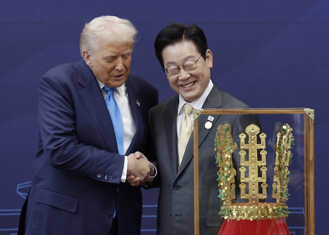 이재명 대통령(오른쪽)이 29일 경북 경주박물관에서 열린 한미 공식 환영식에서 도널드 트럼프 미국 대통령에게 무궁화 대훈장을 수여하고 천마총 금관 모형을 선물하고 있다. 대통령실사진기자단