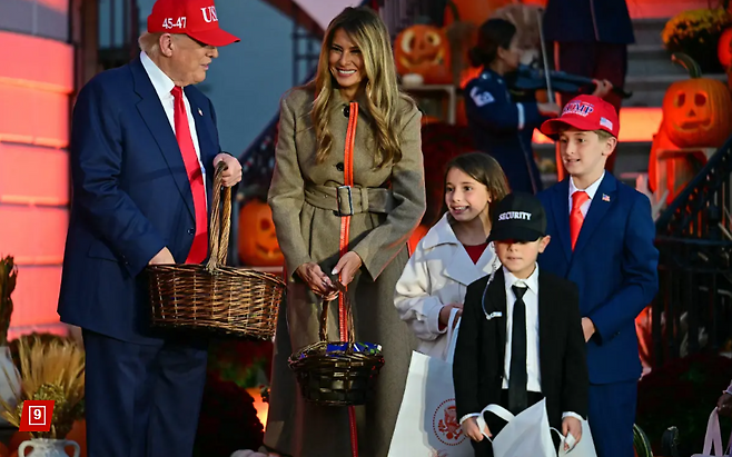 도널드 트럼프 미국 대통령이 30일(현지시간) 멜라니아 트럼프 여사와 함께 백악관에서 열린 할로윈 행사에 참석해, 각양각색의 복장을 한 수백 명의 어린이들에게 초콜릿을 나눠주고 있다. 대통령 부부 앞에는 트럼프 대통령과 멜라니아 여사, 그리고 비밀경호국 요원으로 각각 분장한 세 남매가 주목을 받았다.  [뉴욕포스트 캡처]