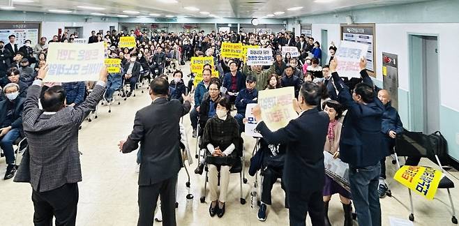 지난달 31일 오전 대구 동구청 민방위교육장에서 열린 대구 도시철도 4호선 주민설명회에서 동구 주민들이 피켓을 들고 반발하고 있다. /황인무기자