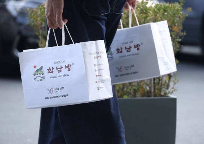 1일 경주 아시아태평양경제협력체(APEC) 정상회의 공식 협찬사인 황남빵 본점에서 시민들이 구매한 황남빵을 들고 이동하고 있다.(사진=연합뉴스.)