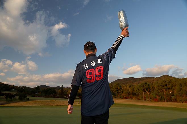 김재호가 2일 페럼클럽에서 열린 KPGA투어 렉서스 마스터즈에서 데뷔 17년 만에 첫 승을 따낸 뒤 부친 김용희 롯데 2군 감독의 유니폼을 입고 포즈를 취하고 있다. 사진 | KPGA