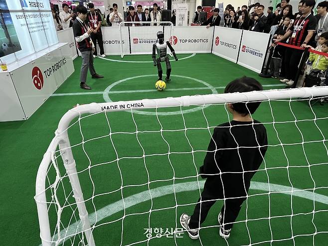 해외 로봇의 국내 대여·판매 전문 유통 업체인 탑 로보틱스의 휴머노이드 로봇이 ‘2025 미래혁신기술박람회’를 찾은 어린이 관객을 상대로 골을 넣기 위해 공을 찰 준비를 하고 있다. 권재현 선임기자