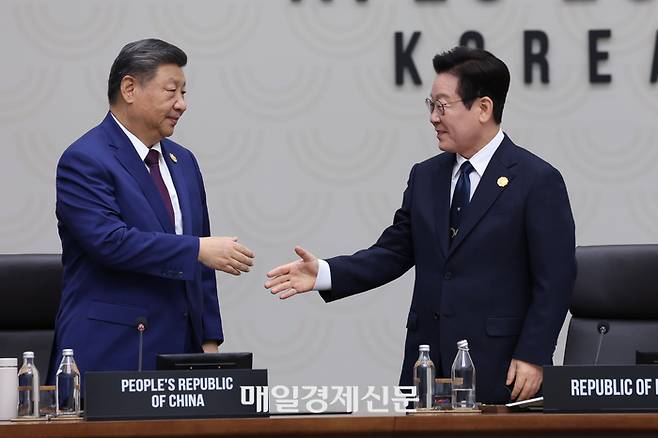 이재명 대통령(오른쪽)이 1일 경주화백컨벤션센터(HICO)에서 열린 2025 아시아태평양경제협력체(APEC) 정상회의 의장국 인계식에서 2026 APEC 의장국인 중국의 시진핑 국가주석에게 의장직 지위를 넘기며 악수하고 있다.[경주 김호영 기자]
