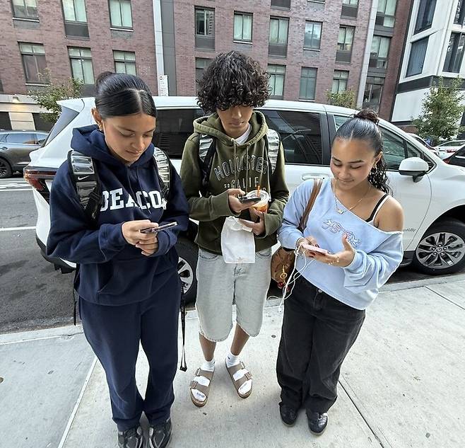 미국 뉴욕시 맨해튼 미드타운 웨스트지역 비컨 고등학교 재학 중인 미갤(사진 중앙) 군이 친구들과 스마트폰을 보고 있다.