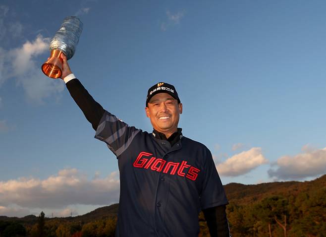‘미스터 자이언츠’ 김용희 프로야구 롯데 2군 감독의 아들 김재호가 2일 한국프로골프(KPGA)투어 렉서스 마스터즈에서 데뷔 17년 만에 우승한 뒤 롯데 유니폼을 입은 채 우승 트로피를 들어 보이고 있다. KPGA투어 제공
