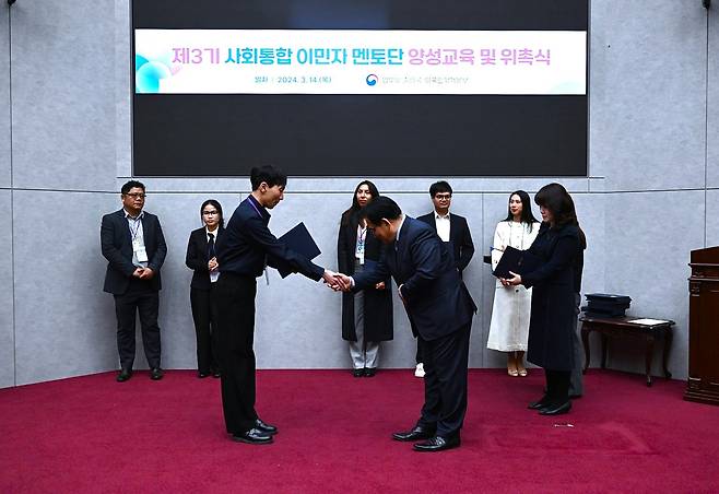 Kobessov Rakhat shakes hands with an official from the Korea Immigration Service at an award ceremony. [KOBESSOV RAKHAT]