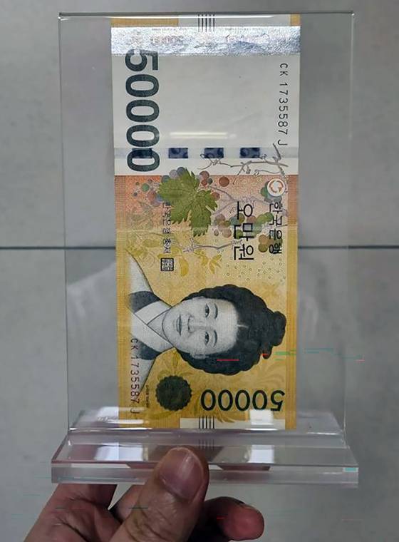 A 50,000 won ($35) bill that Samsung Electronics Executive Chairman Lee Jae-yong gave to a cafe employee in return for a free cup of coffee is displayed in a frame. [SCREEN CAPTURE]