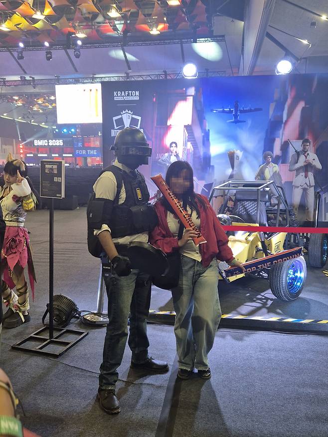 ‘BMIC 2025’ 행사장에서 한 관객이 배틀그라운드 캐릭터 코스프레를 한 인플루언서와 인증샷을 찍고 있다. <김태성 기자>