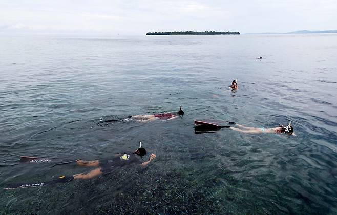 마나도 부나켄 해양국립공원에서 스노쿨링 즐기는 관광객들