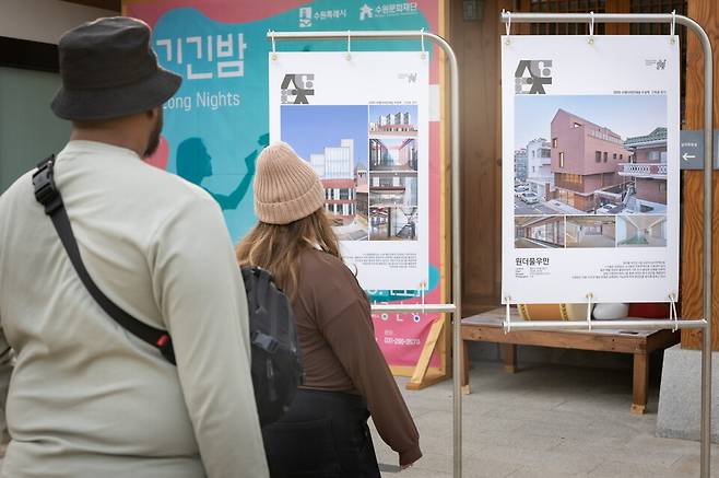 ▲&nbsp;지난 10월30일 2025 수원도시건축문화제가 열린 수원시 정조테마공연장에서 외국인들이 2025 수원디자인대상 작품 사진을 감상하고 있다. /&nbsp;사진제공=수원특례시