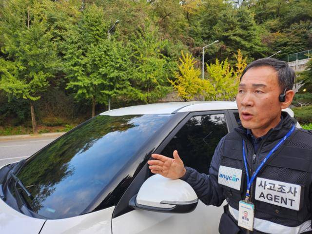 교통사고조사원 김인식씨가 사고현장 출동 대기 중 교통사고조사원들이 처한 열악한 노동환경을 토로하고 있다. 김씨는 삼성화재애니카 조끼와 명함을 쓰지만 법적 신분은 회사 근로자가 아닌 특수고용노동자(개인사업자)다. 송주용 기자
