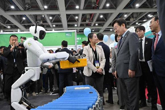 이재명 대통령(오른쪽에서 세번째)이 지난달 24일 대구 EXCO에서 열린 FIX 2025 전시관에서 에이로봇 부스를 찾아 엄윤설 에이로봇 대표(오른쪽에서 네번째)와 휴머노이드 로봇 '엘리스'의 시연을 보고 있다. 이재명 대통령 뒤로는 하정우 AI수석. [사진=에이로봇]