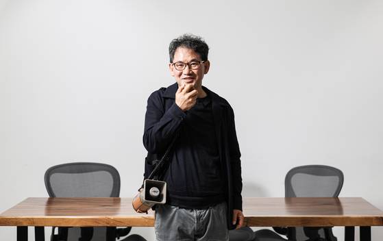 남규홍 PD가 지난달 28일 오후 서울 양천구 촌장엔터테인먼트 사무실에서 중앙일보와 인터뷰를 하며 촬영 소품으로 쓰인 확성기를 든 채 말하고 있다. 사무실은 평소 데프콘, 이이경, 송해나 등 패널들이 나솔 촬영본을 보며 멘트를 하는 스튜디오로도 쓰인다. 김경록 기자