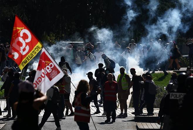 Masked protesters run amid tear gas during clashes with French police at a demonstration in Nantes as part of a day of nationwide strikes and protests against the government and cuts in the next budget, with supporters of the ″Bloquons Tout″ (Let's Block Everything) movement, on Sept.18.  [REUTERS/YONHAP]