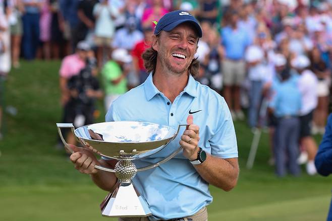 Tommy Fleetwood holds the FedExCup Trophy on the 18th green after winning the Tour Championship in Atlanta, Georgia, on Aug. 24. [REUTERS/YONHAP]