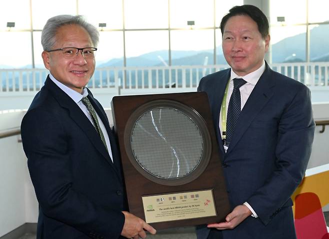 젠슨 황 엔비디아 CEO가 지난달 31일 경북 경주 예술의전당에서 열린 아시아태평양경제협력체(APEC) 최고경영자(CEO) 서밋에 참석해 최태원 대한상의 회장으로부터 SK하이닉스의 HBM4 반도체 웨이퍼를 선물로 받고 있다. 연합뉴스