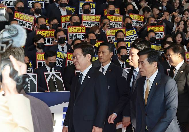 4일 내년도 정부 예산안에 대한 시정연설을 하기 위해 서울 여의도 국회에 도착한 이재명 대통령이 피켓시위를 하는 국민의힘 의원들 앞을 지나고 있다. 국민의힘 의원들은 추경호 전 원내대표에 대한 내란특검팀의 영장청구에 반발하며 야당 탄압 중단을 촉구하는 의미로 ‘검은 마스크’와 ‘상복’차림으로 침묵시위를 벌이고 있다.  [연합]
