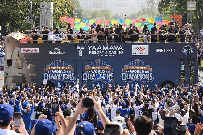 다저스 선수단이 4일(한국시간) 미국 캘리포니아주 LA 도심에서 열린 우승 기념 카 퍼레이드에서 대형 2층 버스에 올라 팬들과 함께  우승 자축 행사를 즐기고 있다. 다저스는 지난 2일 로저스센터에서 열린 토론토와 ‘2025 MLB PS’ 월드시리즈 7차전에서 연장 11회 혈투 끝에 5-4로 이겼다. 시리즈를 4승3패로 끝내며 2년 연속 우승컵을 들어올렸다. LA(미 캘리포니아주)｜AP뉴시스