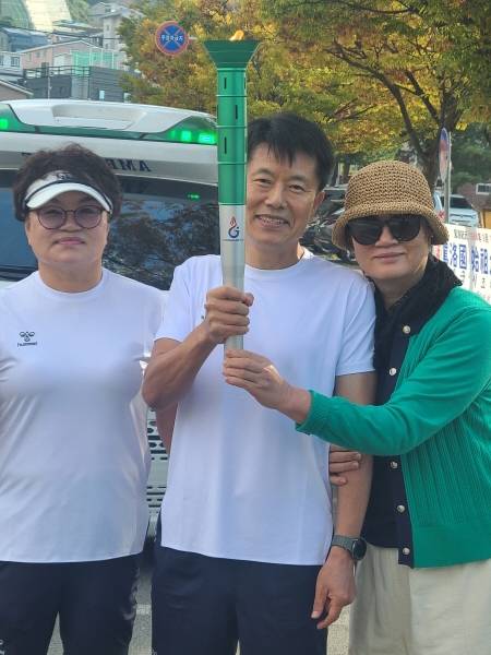 신형식 회장이 제106회 전국체전 성화를 들고 기념촬영하고 있다.