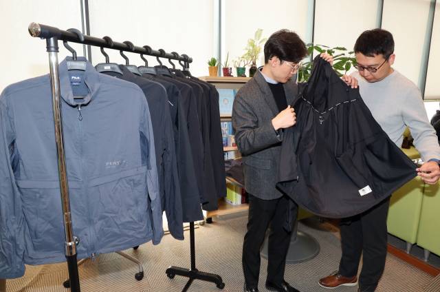 한국소비자원이 5일 정부세종청사 공정거래위원회 기자실에서 소비자 선호도가 높은 러닝 재킷 8개 제품에 대한 품질 및 안전성 등을 시험·평가한 비교정보를 발표했다. 사진은 관계 직원이 시험 제품을 살펴보는 모습. 연합뉴스