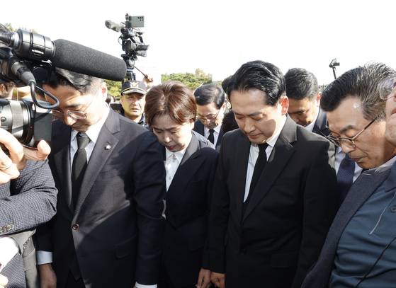 장동혁 국민의힘 대표가 6일 광주 국립 5·18민주묘지를 막아서는 광주전남촛불행동 회원들에게 둘러쌓여 참배는 못하고 간단히 묵념을 올리고 있다. 뉴스1