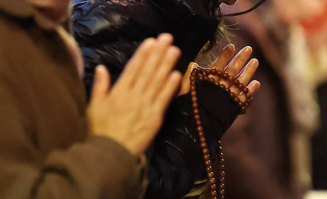 Parents pray for their test-taking children on Monday at Jogyesa in Seoul. (Yonhap)