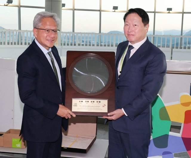 최태원(오른쪽) SK그룹 회장 겸 대한상공회의소 회장이 31일 경북 경주시 경주예술의전당에서 열린 아시아태평양경제협력체(APEC) CEO 서밋에서 젠슨 황 엔비디아 최고경영자(CEO)에게 6세대 고대역폭메모리(HBM4) 웨이퍼를 선물하고 있다. 조태형 기자 2025.10.31