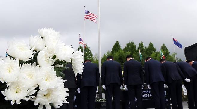 '제75주년 6·25전쟁 참전 유엔전몰용사 추모제'가 열린 지난 6월 25일 부산 남구 유엔기념공원에서 참석자들이 전몰장병묘역에 헌화한 뒤 묵념을 하고 있다.유엔기념공원에는 총 14개국 2332명의 유엔군 전몰장병이 잠들어 있다. 뉴시스