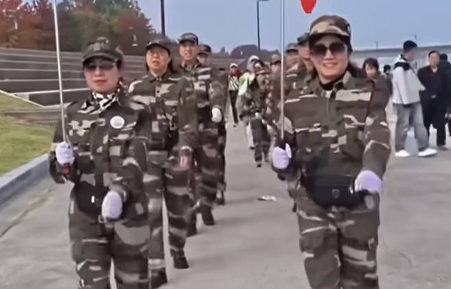 A group of Chinese nationals has drawn controversy for marching in formation along the Han River in Seoul in what some online users mistook for a military drill, due to their outfits resembling military uniforms and bright red clothing. [SCREEN CAPTURE]