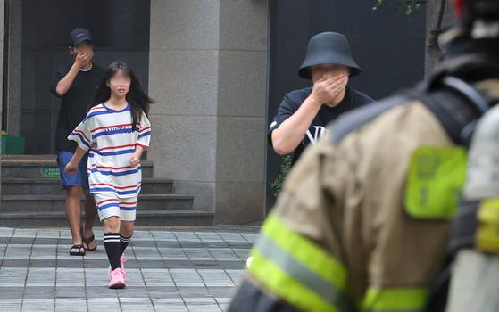 People run out of apartments as a fire broke out in a Mercedes EV parked in an underground parking lot in Incheon on Thursday. [YONHAP]