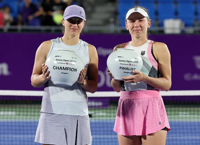 Winner Iga Civil Tech (left) and runner-up Ekaterina Alexandrova taking a commemorative photo on the podium in the singles final of this year's Women's Professional Tennis (WTA) Tour Korea Open. Yonhap News