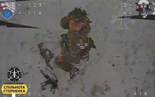 아무리 도망쳤지만, 끝내 우크라이나 무인기를 따돌리지 못한 북한 특수작전군 병사가 죽음 직전에 총을 버리고 두 손으로 머리를 감싸고 있다. 우크라이나 국방부 텔레그램.