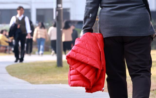 서울 낮기온이 20도에 육박하며 포근한 가을 날씨를 보인 지난 6일 서울 종로구 열린송현 녹지광장에서 시민들이 겉옷을 손에 든 채 오가고 있다. 연합뉴스