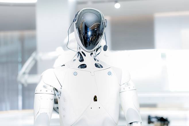 5일 중국 광둥성 광저우에서 열린 2025 AI 데이 행사에서 샤오펑의 휴머노이드 로봇 2세대 아이언을 허샤오펑 CEO가 설명하고 있다. 샤오펑은 인공지능 칩 튜링 을 탑재한 해당 로봇을 내년 1000대 규모로 양산할 계획이다. 이 로봇은 인간형 척추 구조를 바탕으로 82개 관절을 정밀 제어해 사람처럼 걷고 움직인다. [샤오펑]