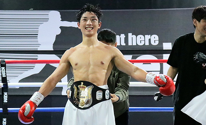 WE BOX 신인왕전 우승자 이찬이 2025년 10월 노바복싱 문병수 대표가 사단법인 한국복싱커미션 웰터급 챔피언 벨트를 채워주자 감격하고 있다. 사진=KBM