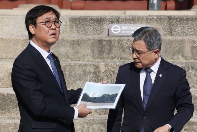 최휘영(왼쪽) 문화체육관광부 장관과 허민 국가유산청장이 7일 서울 종묘를 찾아 정전 월대에서 바라보이는 전경을 점검하고 있다. 최 장관이 들고 있는 종이에는 세운4구역 고층건물이 들어섰을 때 모습을 예상한 그림이 그려져 있다. 연합뉴스