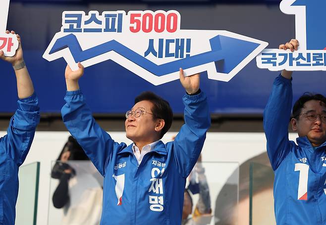 President Lee Jae Myung, then the Democratic Party’s presidential candidate, holds up a sign reading “Kospi 5000 era” during a campaign rally in Seocho District, southern Seoul, on May 29. [YONHAP]