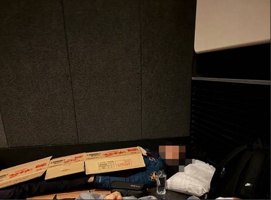 A police officer deployed to the 2025 Asia-Pacific Economic Cooperation (APEC) summit in Gyeongju, North Gyeongsang, sleeps under a cardboard box in this undated photo released by the Korean National Police Workers Council. [KOREAN NATIONAL POLICE WORKERS COUNCIL]