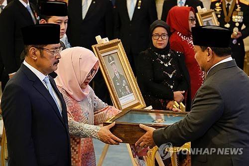 수하르토 유족에게 '국가 영웅' 기념패 주는 프라보워 대통령 [로이터 연합뉴스]
