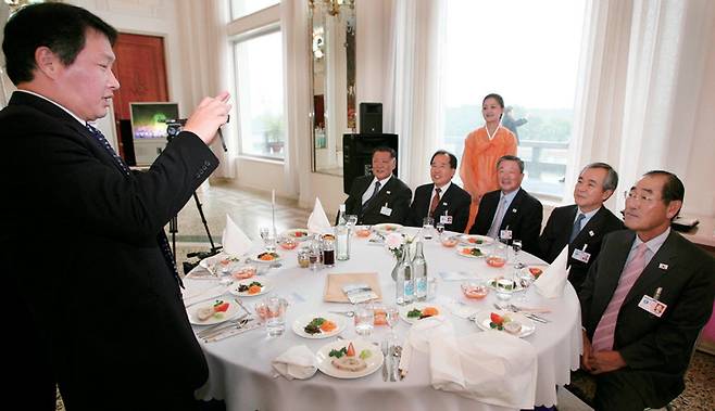 2007년 10월3일 기업 방북단의 일원이었던 최태원 SK회장이 평양 옥류관에서 구본무 LG 회장, 정몽구 현대차 회장, 윤종용 삼성전자 부회장, 이구택 포스코 회장 등에게 기념사진을 찍어주고 있다. ⓒ연합뉴스