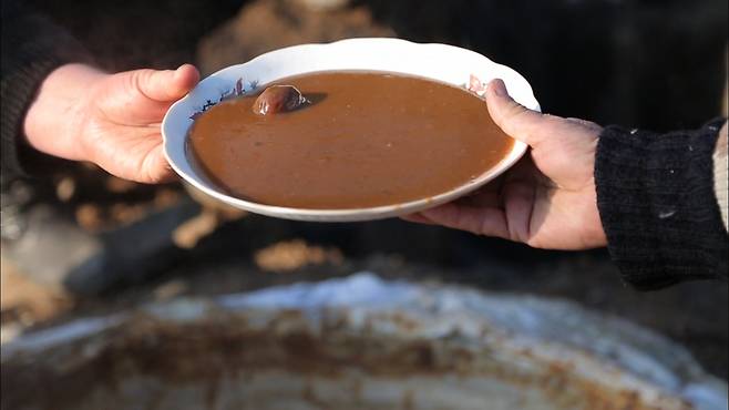 손으로 주고 받는 액젓이 담긴 접시