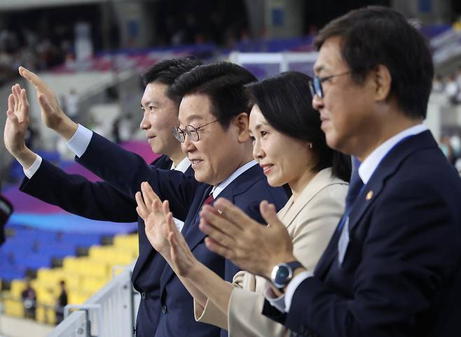 이재명 대통령과 김혜경 여사가 지난달 17일 부산아시아드주경기장에서 열린 전국체전 개막식에서 입장하는 선수단을 향해 손을 흔들고 있다. 왼쪽부터 유승민 대한체육회장, 이재명 대통령, 김혜경 여사, 최휘영 문체부 장관. 사진 | 연합뉴스