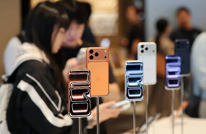 A customer looks at an iPhone 17 model on display at the Apple Store in Myeong-dong, central Seoul, on Sept. 19. [NEWS1]