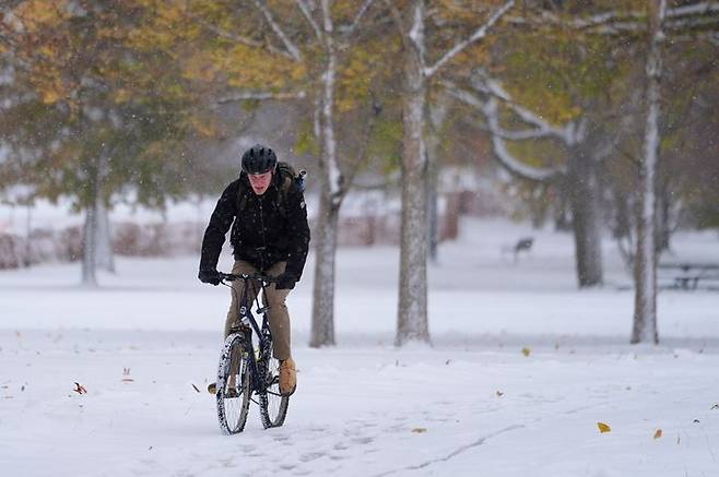 [시카고=AP/뉴시스]    雪が降った１０日（現地時間）、米イリノイ州シカゴ郊外のエバンストンで自転車に乗っている市民。 2025.11.11。