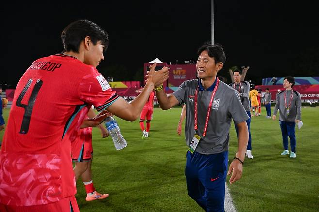 U-17&nbsp;축구대표팀 백기태 감독(오른쪽)이 10일(한국시간) 카타르 도하 어스파이어존에서 열린 U-17 월드컵 조별리그 F조 3차전에서 코트디부아르를 3-1로 이긴 뒤 수비수 정희섭과 손을 맞잡고 있다. 사진제공｜대한축구협회