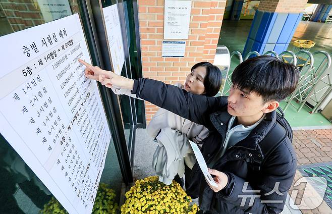 2026학년도 대학수학능력시험을 하루 앞두고 예비 소집이 실시된 12일 서울 은평구 은평고등학교에서 수험생과 학부모가 시험실 위치를 확인하고 있다. 2025.11.12/뉴스1 ⓒ News1 이호윤 기자