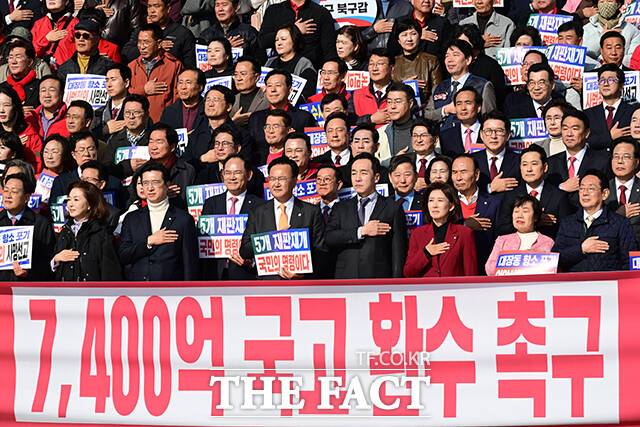 장동혁 국민의힘 대표를 비롯한 참석자들이 12일 오전 서울 여의도 국회에서 열린 '대장동 일당 7400억 국고 환수 촉구 및 검찰 항소포기 외압 규탄대회'에 참석해 국기에 경례하고 있다. /국회=남윤호 기자